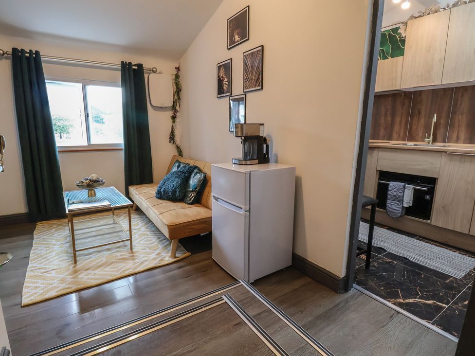 A living room with a sofa, coffee table, and refrigerator at The Cloud Apartment 1 in Chester