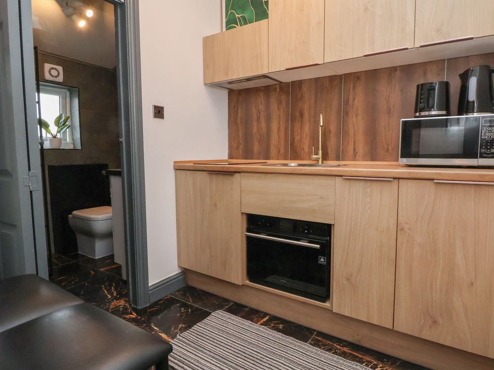 A kitchen with cabinets sink and microwave at The Cloud Apartment 1 Chester
