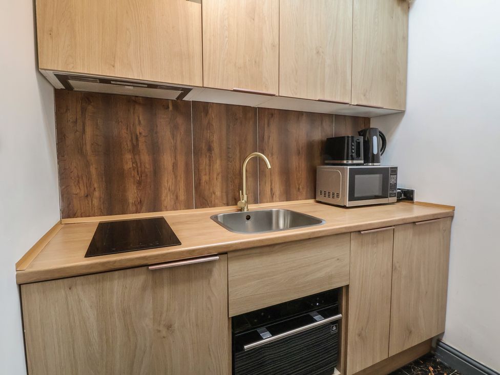 A kitchen with a sink, cooker, microwave, and kettle at The Cloud Apartment 1 Chester