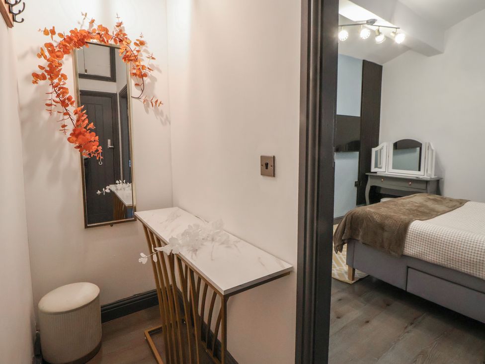 A bedroom with a mirror and table at The Cloud Apartment 1 Chester