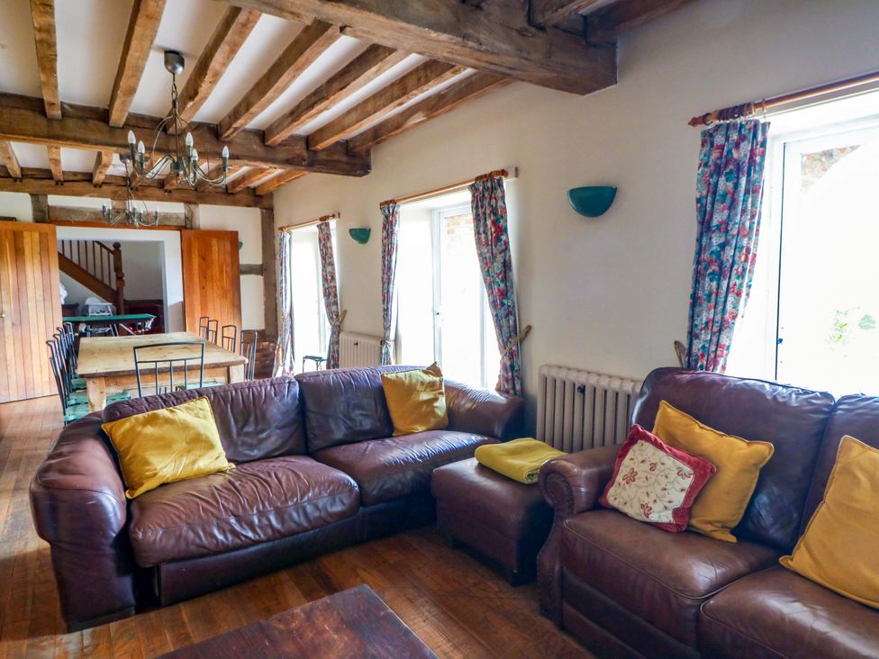 A living room with a sofa, table, and chairs at Gaer Hall in Welshpool