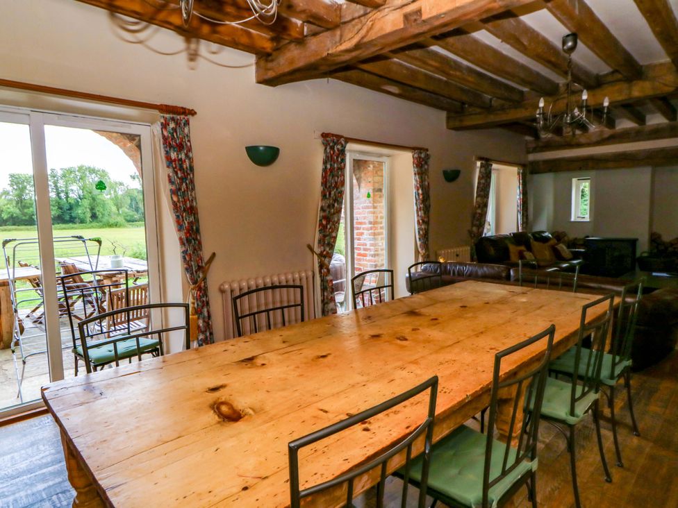 A dining room with a long wooden table and chairs at Gaer Hall in Welshpool