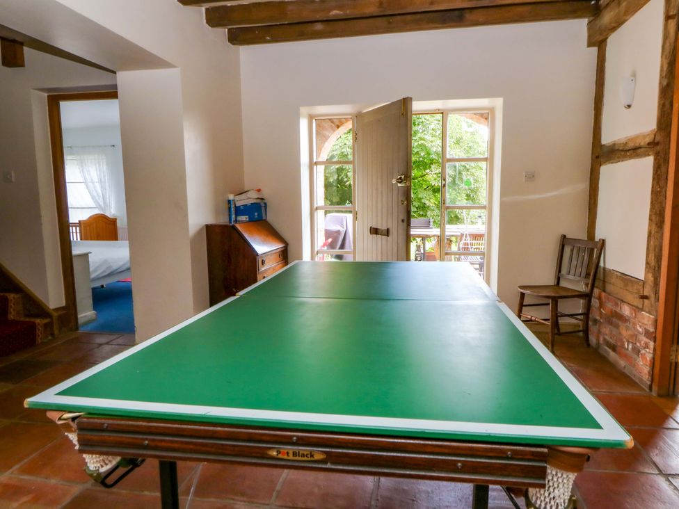 A ping pong table in a room with a door and window at Gaer Hall Welshpool