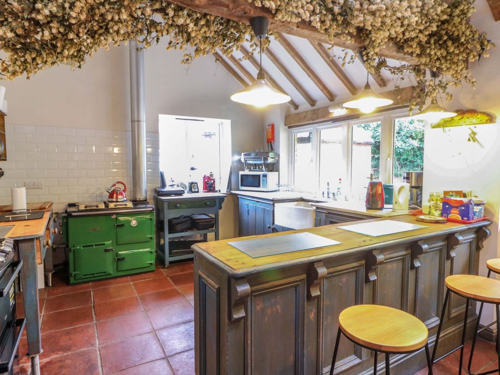 A kitchen with a green stove and bar counter at Gaer Hall in Welshpool