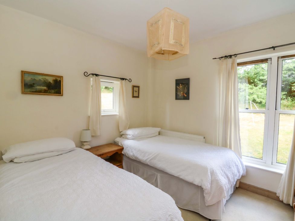 A bedroom with two beds and a window at Gaer Hall in Welshpool