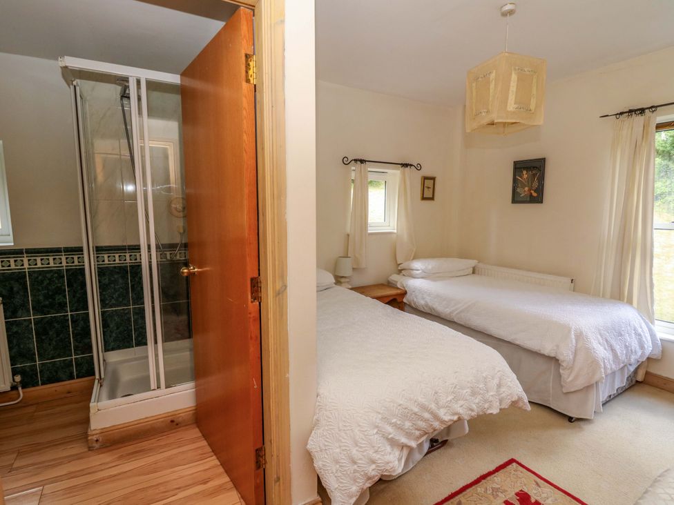 A bedroom with two beds and a shower area at Gaer Hall in Welshpool