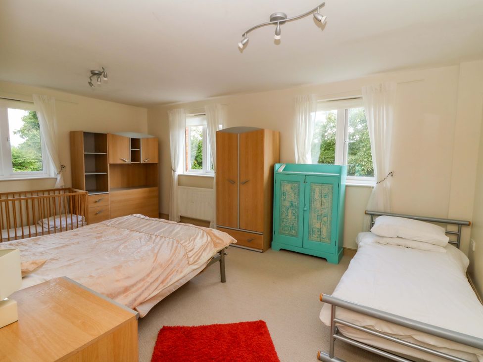 A bedroom with beds and a wardrobe at Gaer Hall in Welshpool