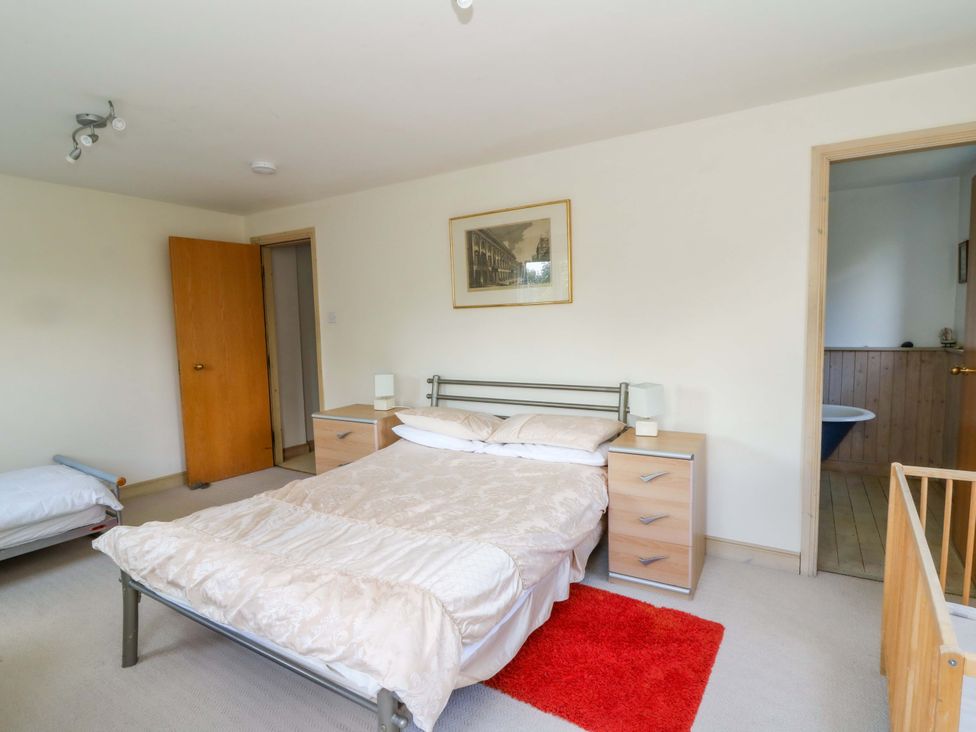 A bedroom with a bed and a door leading to a bathroom at Gaer Hall in Welshpool