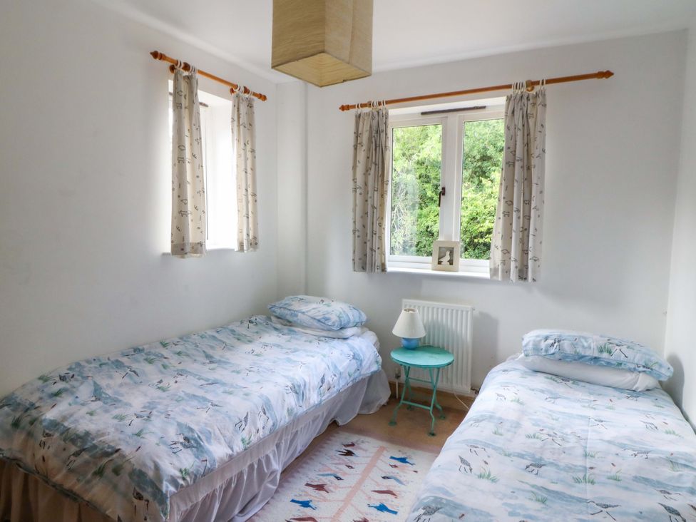 A bedroom with two single beds and a window at Gaer Hall in Welshpool