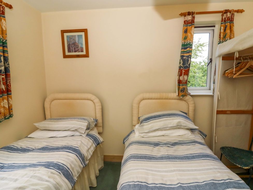 A bedroom with two beds and a window at Gaer Hall in Welshpool