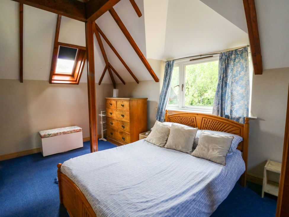 A bedroom with a bed and dresser at Gaer Hall in Welshpool