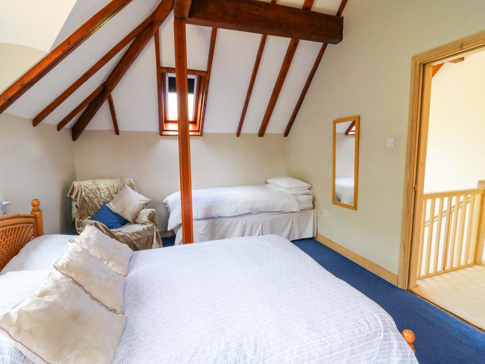 A bedroom with beds and a chair at Gaer Hall Welshpool