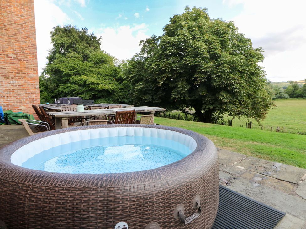 A hot tub and outdoor dining area at Gaer Hall in Welshpool
