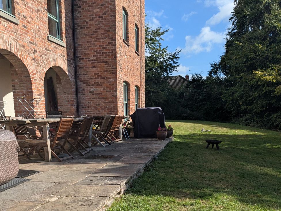 An outdoor patio with table and chairs at Gaer Hall in Guilsfield