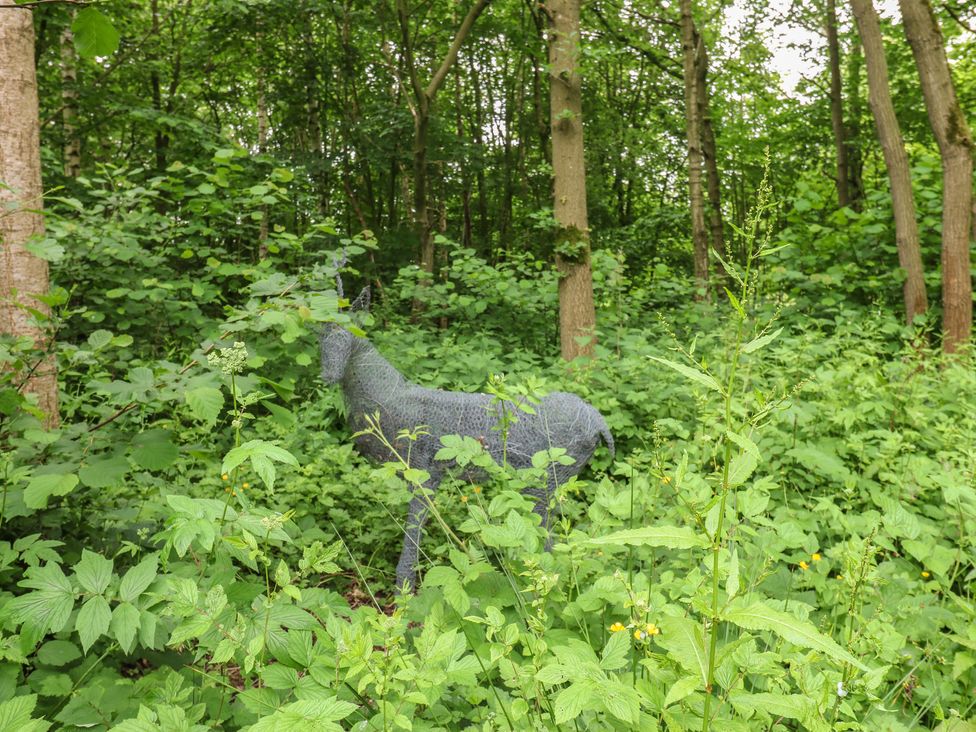 A wire sculpture of a deer among plants in a forest at The Leveret in Eppleby
