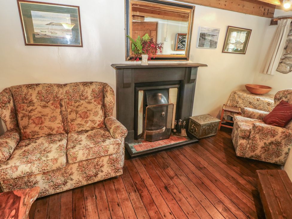 A living room with a fireplace and seating area at Penfeidr Newydd, Carningli Common, Newport, Pembrokeshire