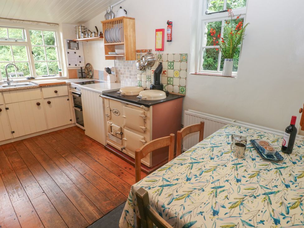 A kitchen with an oven and table at Penfeidr Newydd in Carningli Common, Newport, Pembrokeshire