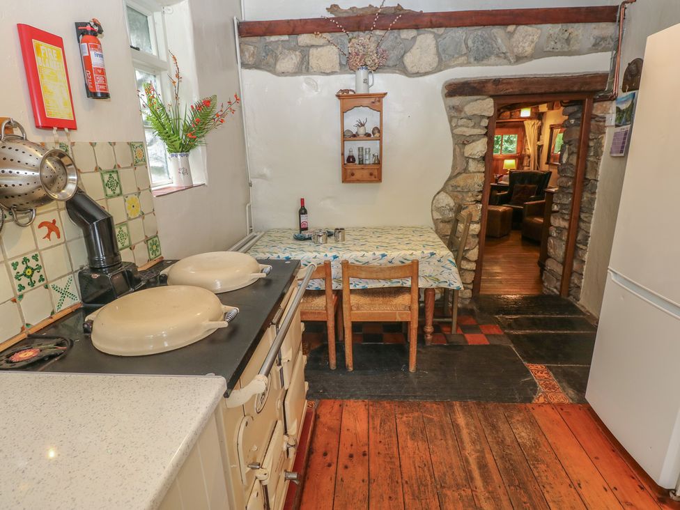 A kitchen with stove and dining table at Penfeidr Newydd, Carningli Common, Newport, Pembrokeshire