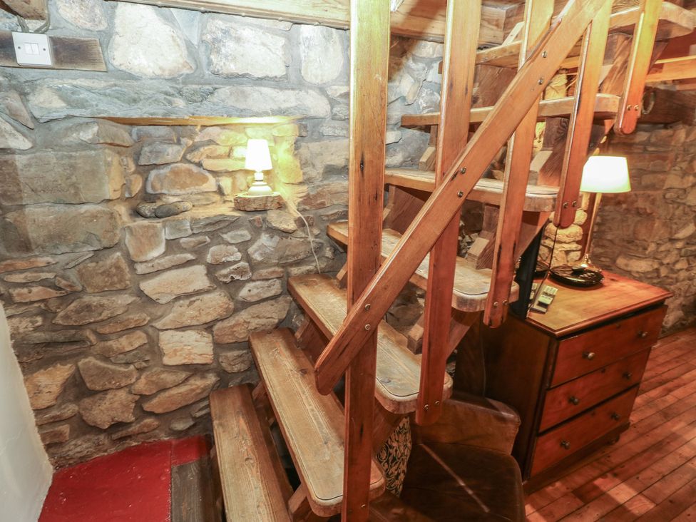 A staircase with wooden stairs and stone wall at Penfeidr Newydd, Carningli Common, Newport, Pembrokeshire