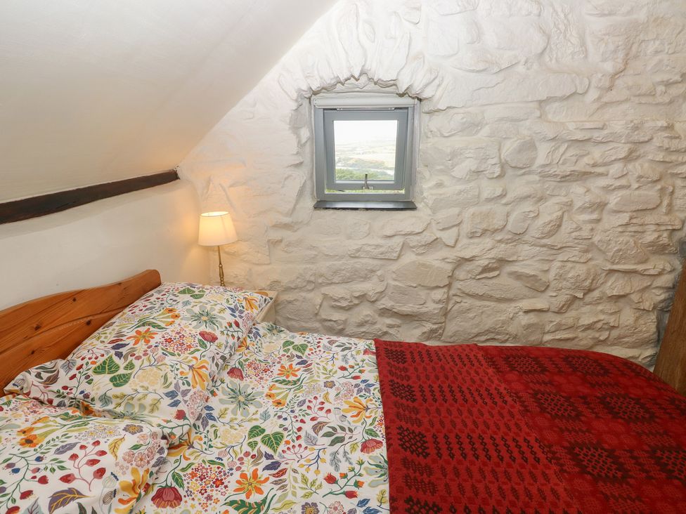 A bedroom with a bed and window at Penfeidr Newydd, Carningli Common, Newport, Pembrokeshire