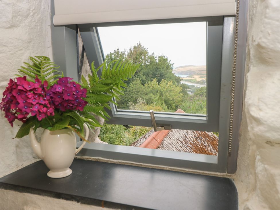 A window with a flower arrangement and teapot at Penfeidr Newydd, Carningli Common, Newport, Pembrokeshire