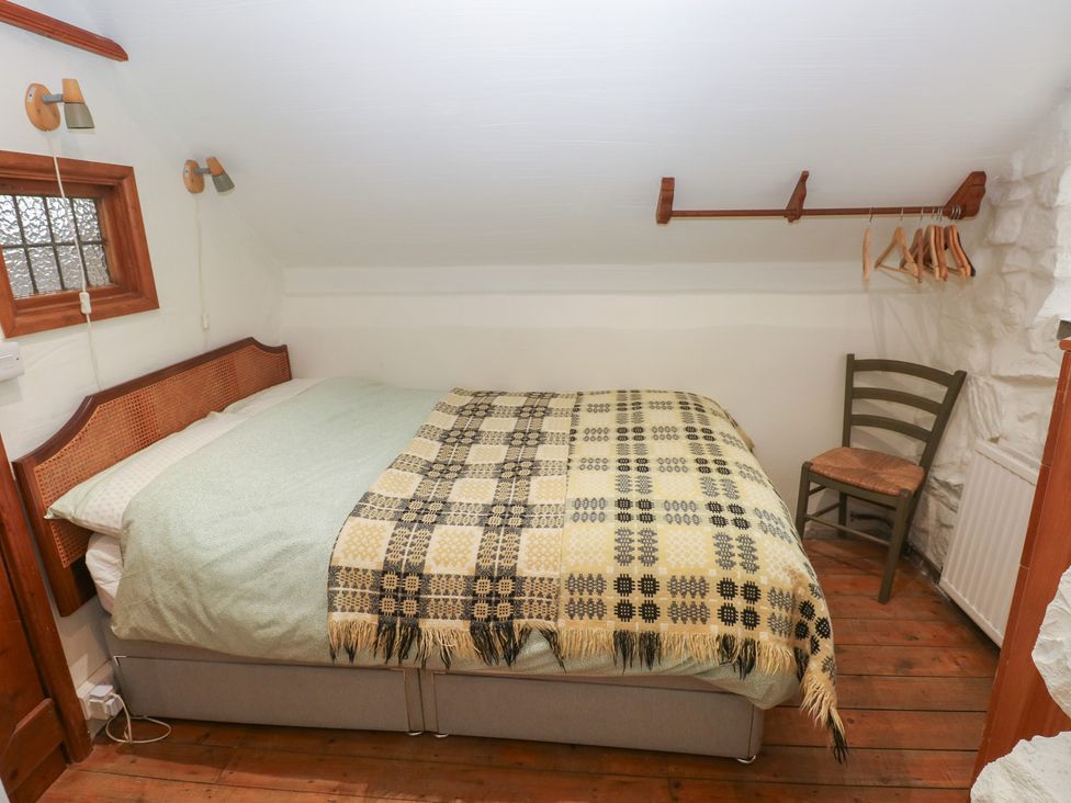 A bedroom with a bed and chair at Penfeidr Newydd in Carningli Common, Newport, Pembrokeshire