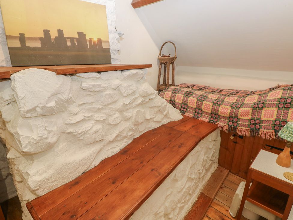 A snug with a wooden bench and artwork on the wall at Penfeidr Newydd, Carningli Common, Newport, Pembrokeshire