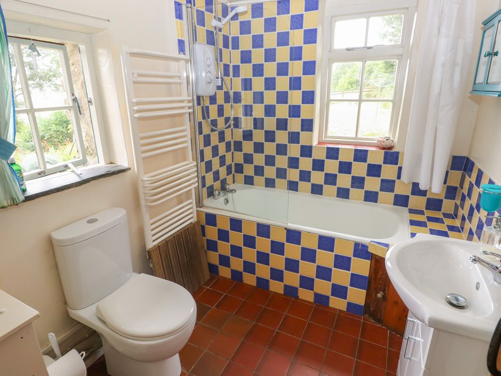 A bathroom with a bathtub, toilet, and sink at Penfeidr Newydd, Carningli Common, Newport, Pembrokeshire