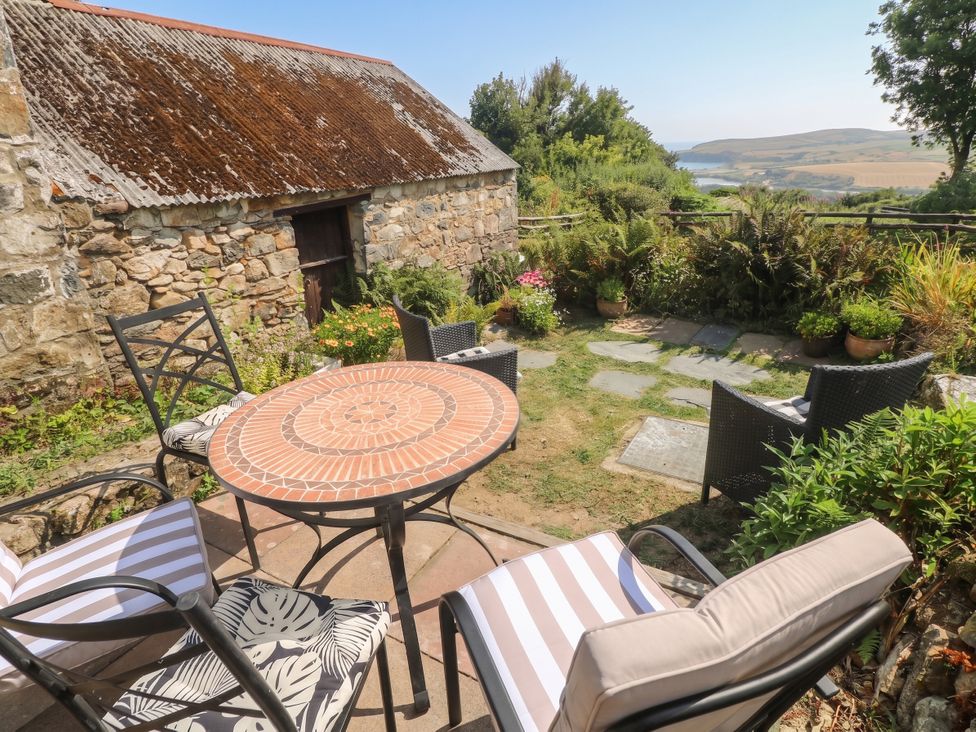 A garden with a table and chairs at Penfeidr Newydd, Carningli Common, Newport, Pembrokeshire
