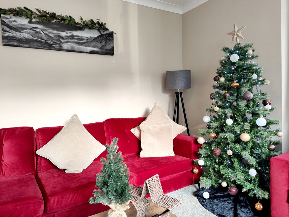 A living room with a Christmas tree and a sofa at The Paddock in Keswick