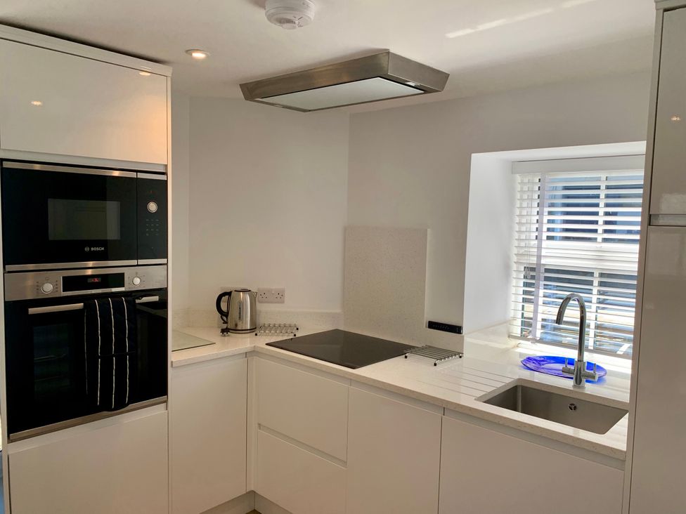 A kitchen with an oven, kettle, sink, and stovetop at Beach Cottage in Cadgwith