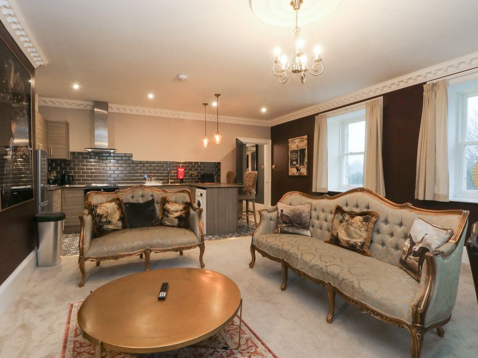 A living room with sofas and a kitchen area at Alexander Cabus near Garstang