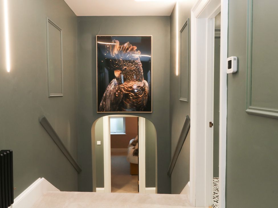 A hallway with a staircase and a framed artwork at Alexander in Cabus near Garstang