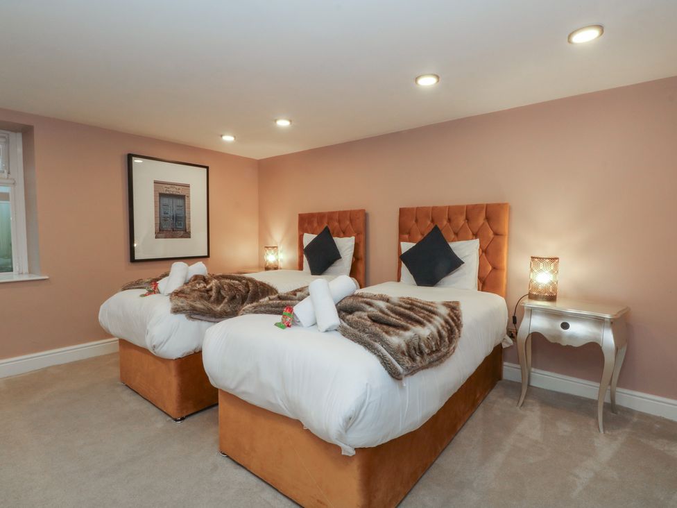 A bedroom with two beds and a bedside table at Alexander Cabus near Garstang