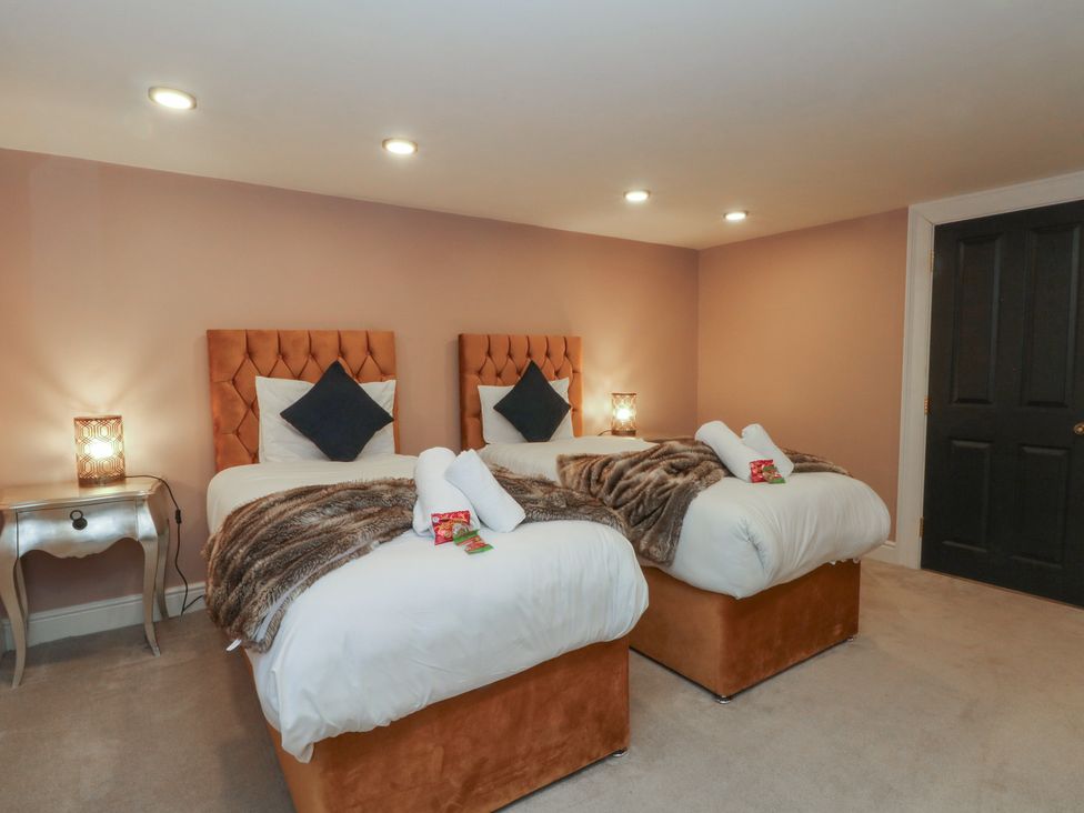 A bedroom with two beds and a nightstand at Alexander in Cabus near Garstang