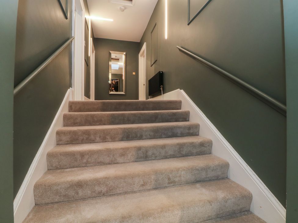 A hallway with stairs and a mirror at Alexander Cabus near Garstang
