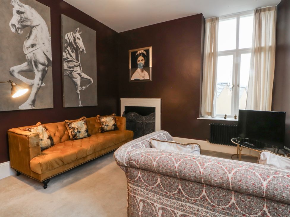 A living room with a sofa and art on the walls at The Hyde in Cabus near Garstang