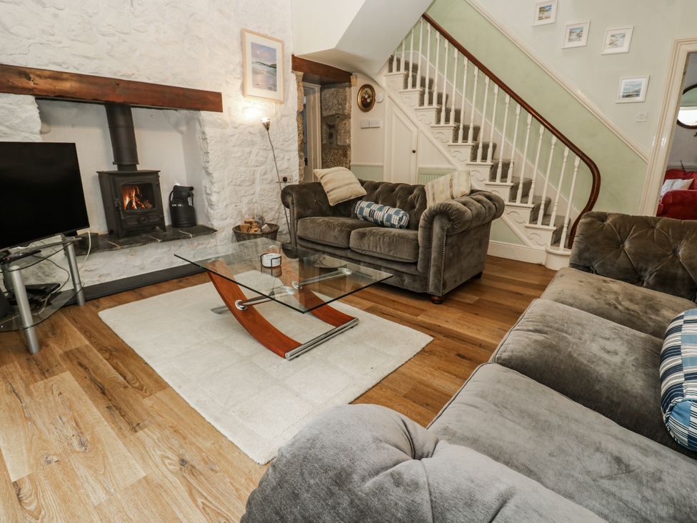 A living room with a fireplace and sofa at Glenside House in Carbis Bay