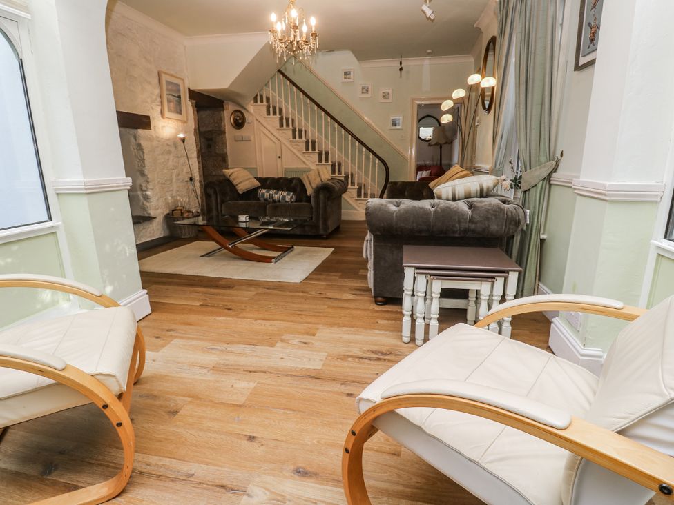 A living room with an armchair, sofa, and coffee table at Glenside House in Carbis Bay
