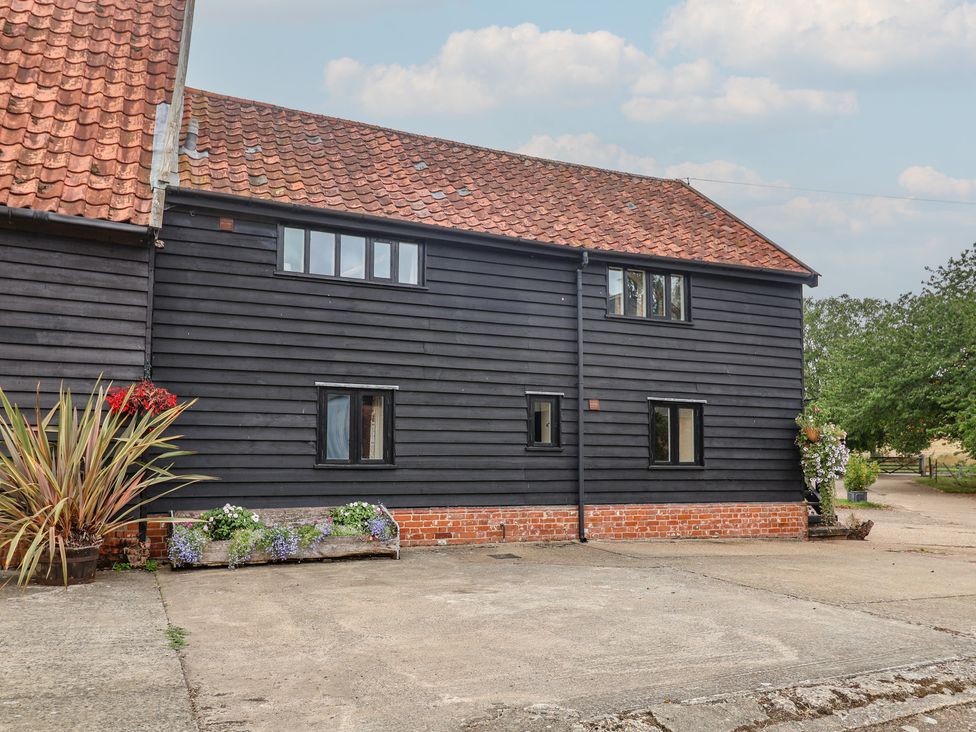 A building with windows and flowers at The Cow Shed in Chediston near Halesworth