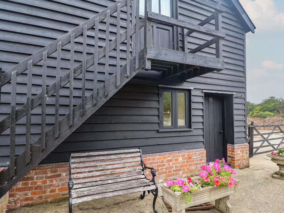 An exterior view with stairs, bench and flowers at The Cow Shed in Chediston near Halesworth