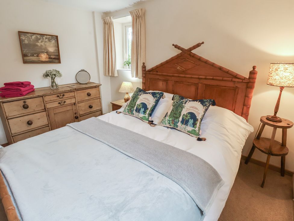 A bedroom with a bed and dresser at The Cow Shed in Chediston near Halesworth