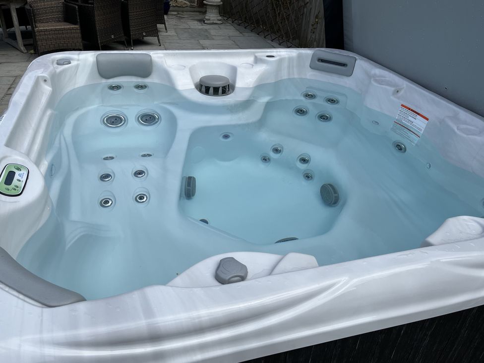A hot tub filled with water in an outdoor area at Riviere House Hayle
