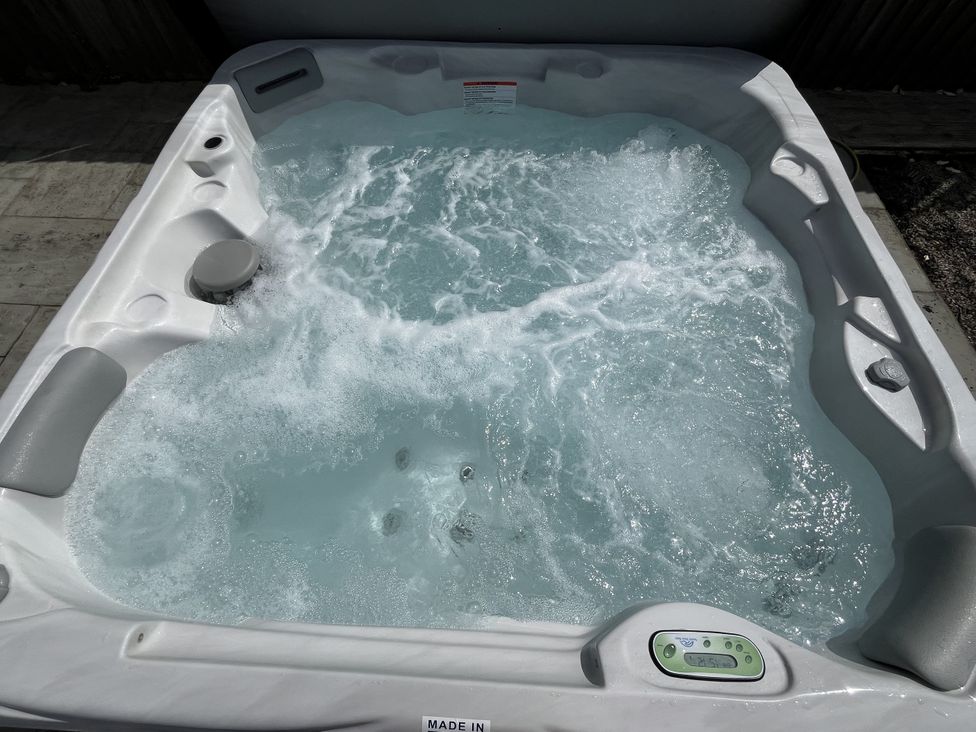 A hot tub with bubbling water and control panel at Riviere House Hayle