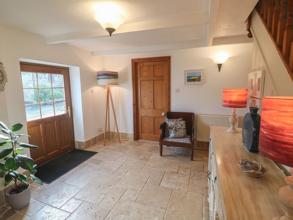 An entryway with a wooden door and lamps at Riviere House Hayle