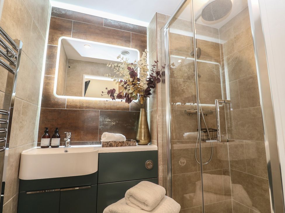 A bathroom with a sink, shower, and decorative vase at Riviere House in Hayle