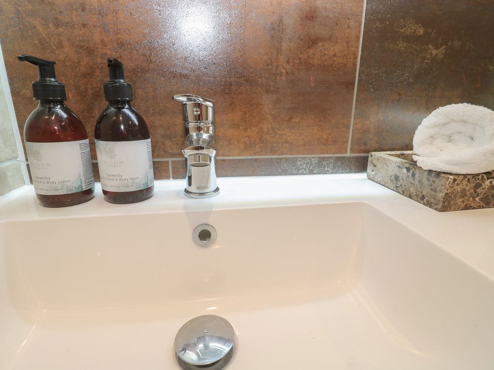A wash basin with lotion and wash bottles at Riviere House in Hayle