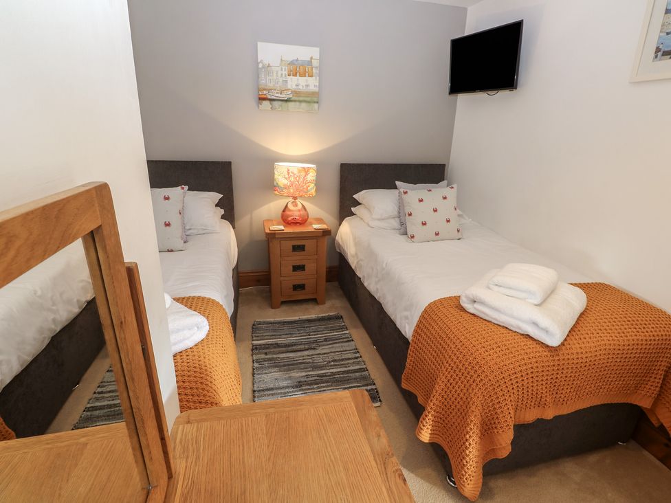 A bedroom with twin beds and a television at Riviere House in Hayle