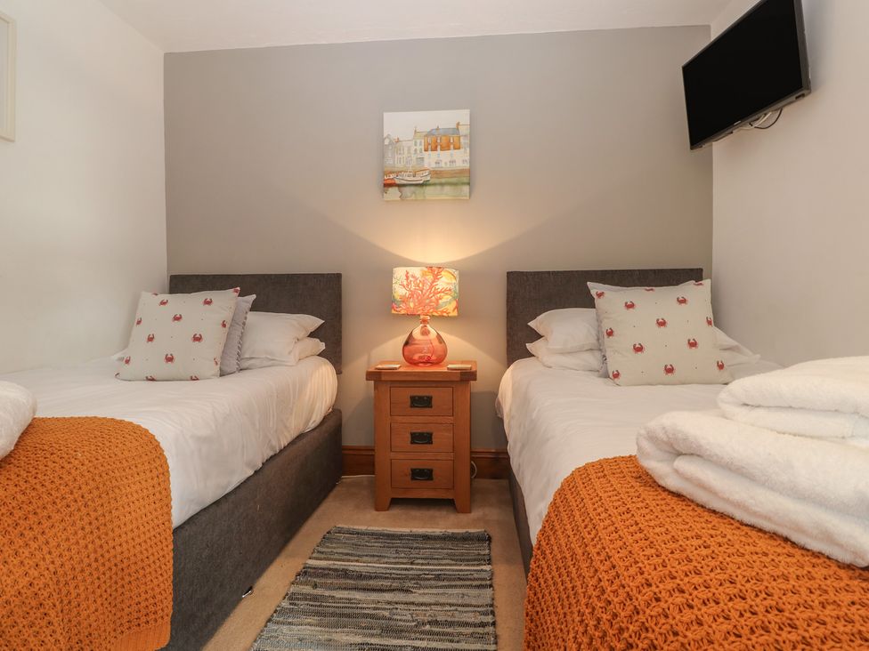 A bedroom with two beds and a bedside table at Riviere House Hayle