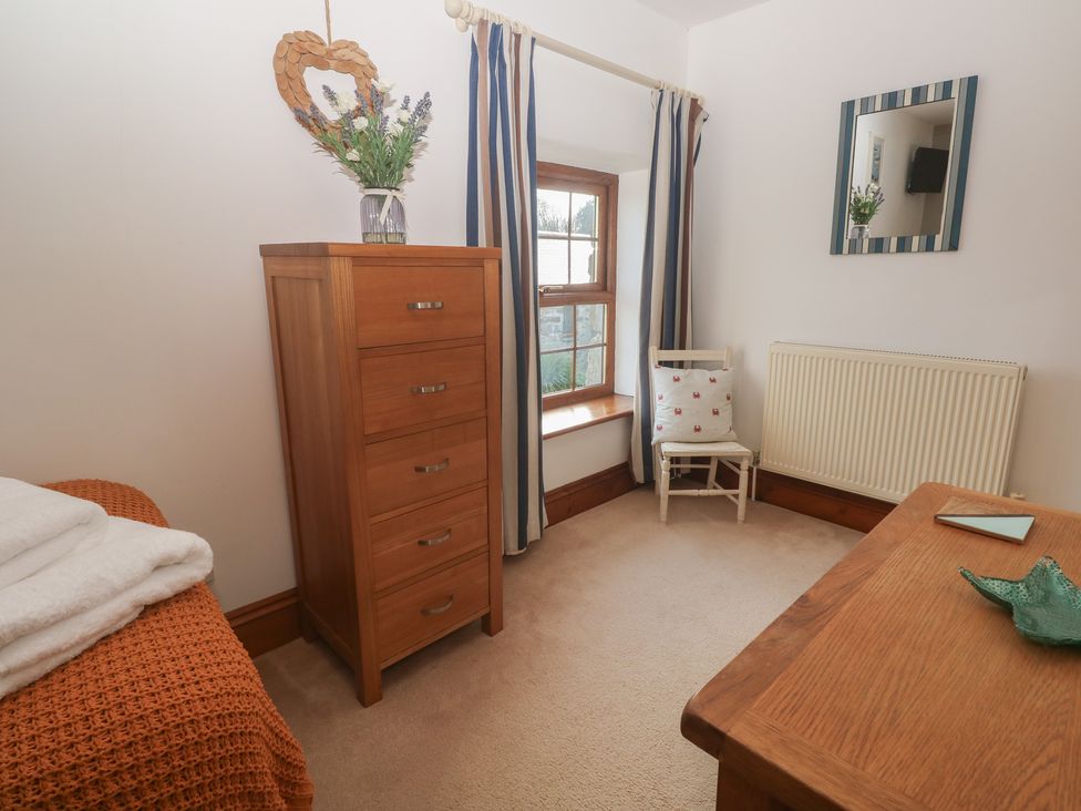 A bedroom with a dresser and a chair at Riviere House in Hayle